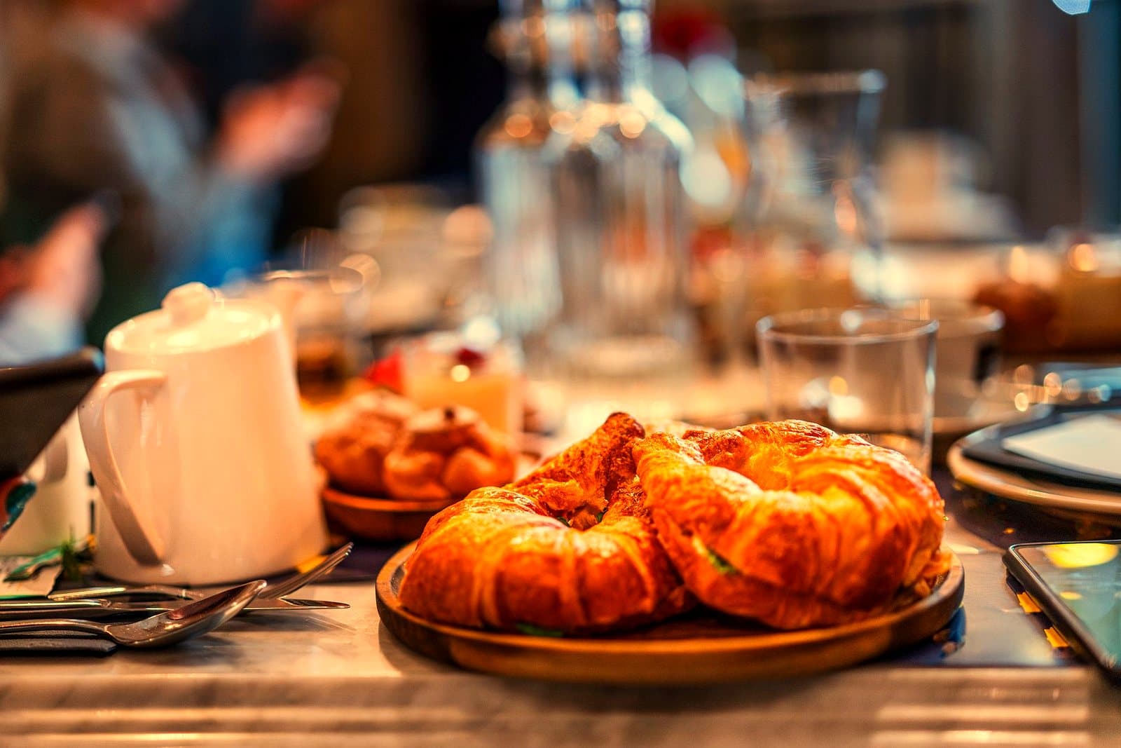 Close-up of croissants on a cafe table with elegant dining setting